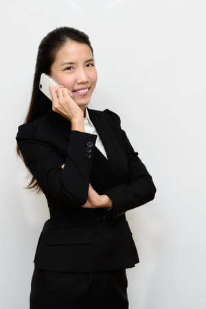 Thai business woman talking with her mobile phoneの写真素材