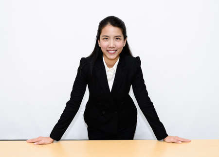 Thai business woman standing and hand on a deskの写真素材