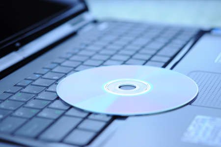 DVD disk lying on a laptop keyboardの写真素材
