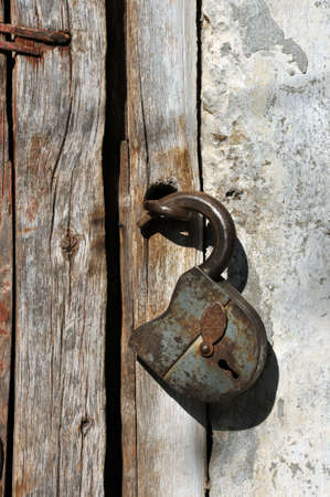 Rusted open padlock on the old wooden doorの写真素材