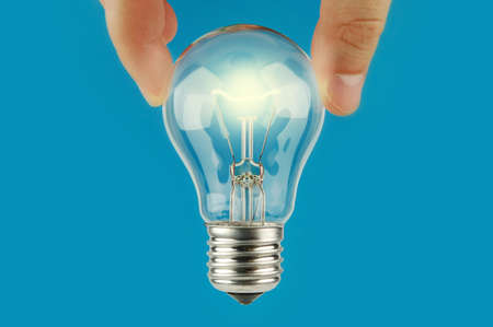 Hand holding glowing a light bulb with blue background. Concept and idea background. Bright idea....
