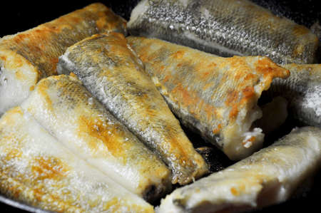 Fried fish in a frying pan. Notothenia. Macro shot.