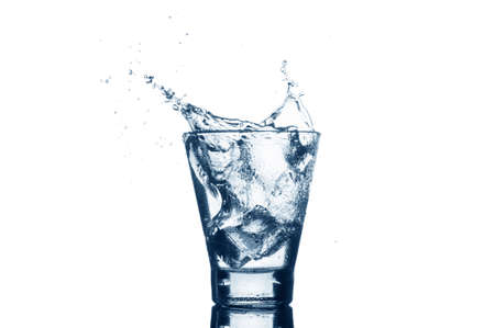 Water with splash and ice isolated on white background. Mineral water with ice in a glass.の写真素材