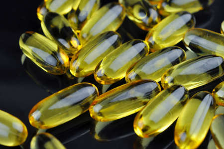 Closeup of capsules fish oil on a black background. Omega 3. Vitamin E.