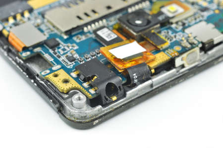Disassembled mobile phone or smartphone. Circuit board, camera, microcircuit, audio jack. Macro...
