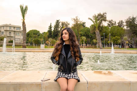 Young woman in a stressful wait, she is depressed and sitting by a pool, depression and anxiety disorderの写真素材