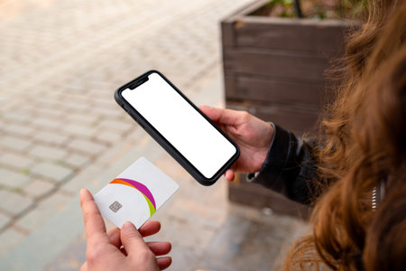 Woman using smartphone for online shopping in close up sitting on a park bench at city park. Outdoor...