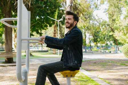 A young man smoking silhouette. One caucasian man portrait smoking cigarette silhouette on a park bench outdoor. Thinking about life, sad man.の写真素材