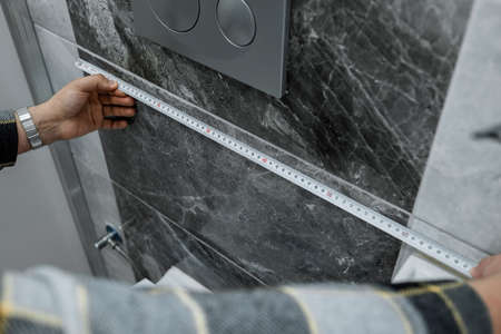 Meter, young marble master takes wall measurements for repair, Marble patterned walls and length...