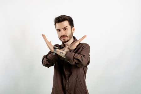 Handsome young man wearing casual clothes posing isolated over white background rejection expression crossing arms and palms doing negative sign, angry faceの写真素材