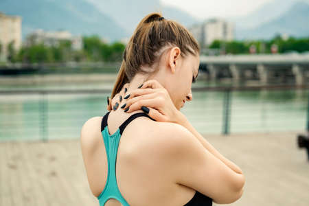Young beautiful woman wearing sportive clothes on city park, outdoors feeling hurt joint shoulder...