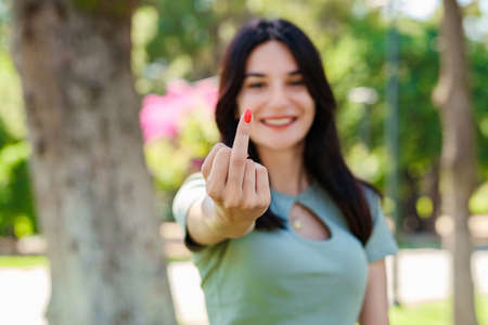 Young brunette girl smiling happy wearing turquoise t-shirt standing on city park, outdoors showing...