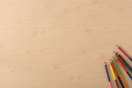 Multiple colour pencils on the  wood texture tableの写真素材