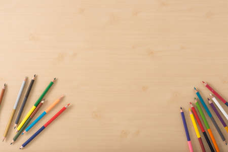 Multiple colour pencils on the  wood texture tableの写真素材