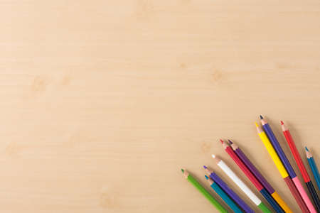 Multiple colour pencils on the  wood texture tableの写真素材