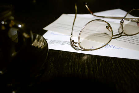 cup hot coffee near by spectacles and letter with markの写真素材