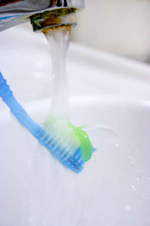 water results from faucet and toothbrush with hygenic paste for peelings teethの写真素材