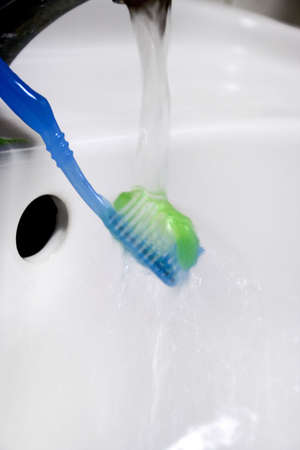 water results from faucet and toothbrush with hygenic paste for peelings teethの写真素材