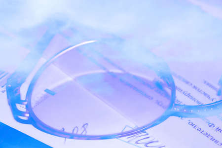 glass spectacles in metallic mount on background documentの写真素材