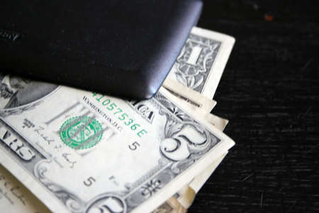 paper dollar bills resting upon dark backgroundの写真素材