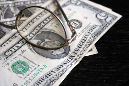 paper dollar bills resting upon dark backgroundの写真素材