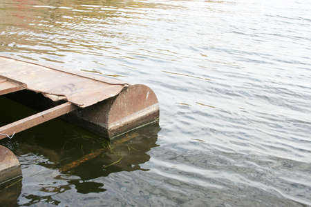 rusty old metallic quay on riverの写真素材