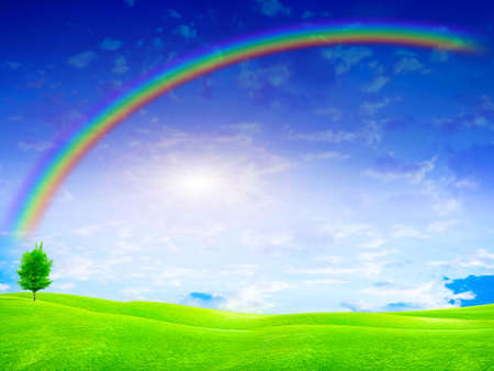 green landscape and rainbow on solar skyの写真素材