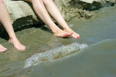 feminine legs on background sand beachの写真素材