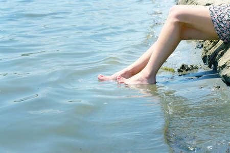 feminine legs on background sand beachの写真素材