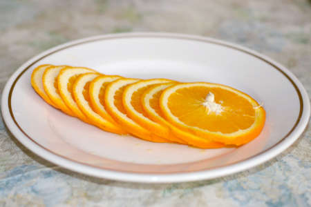 cut on segments orange rests upon light plateの写真素材