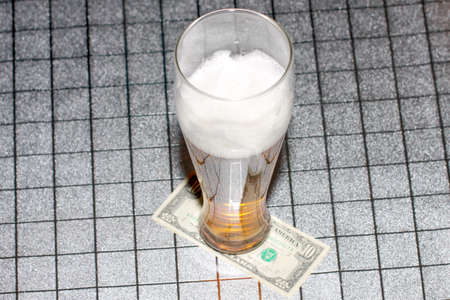 abstract high glass with light beer stands on the tableの写真素材