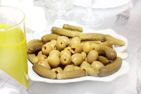 capacity with salt cucumber and green olives on a festive tableの写真素材
