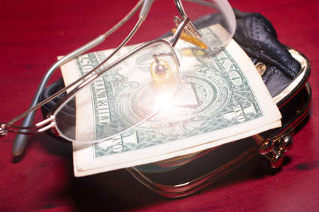 purse, glasses for a correction sight and paper note dollar