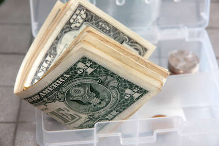 Small paper dollars in a plastic cash drawerの写真素材