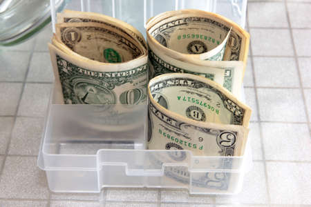 Small paper dollars in a plastic cash drawerの写真素材