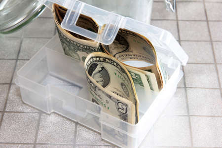 Small paper dollars in a plastic cash drawerの写真素材