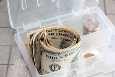 small paper dollars in a plastic cash drawer