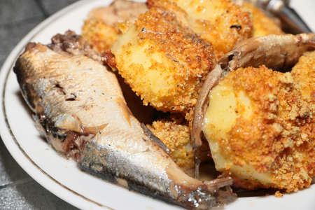 slices of smoked sprats canning and roasted potatoesの写真素材