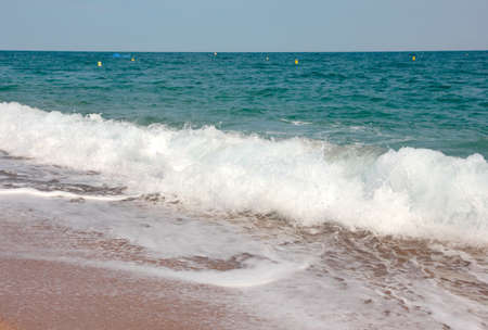 Sandy beach and the waves of the Mediterranean Seaの写真素材