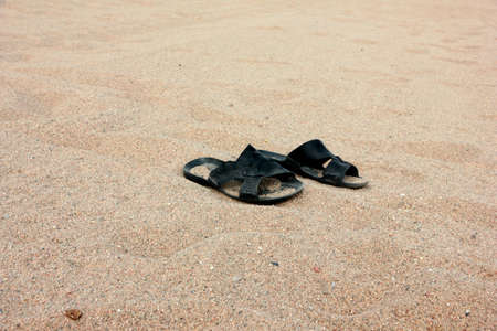 a pair of leather sandals in the sandの写真素材