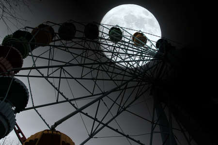 Ferris wheel and moon in the town parkの写真素材