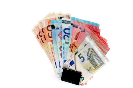 metal clip and a small pile of paper euro banknotesの写真素材