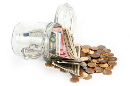 small coins and paper notes in a glass jarの写真素材
