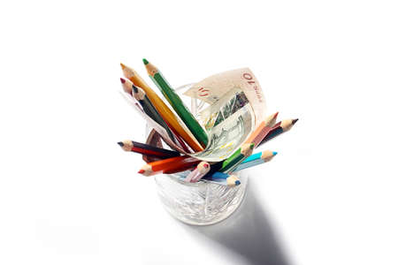 colored pencils in a glass and paper euro banknotesの写真素材