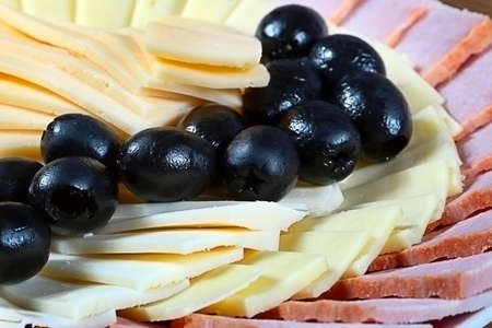 several kinds of sliced ??cheese and bacon on a plateの写真素材