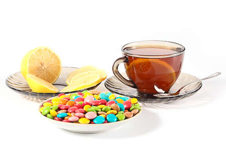 cup of hot tea with lemon and sweetsの写真素材