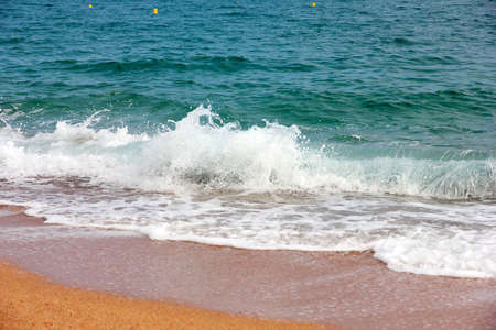 transparent beautiful waves and the sand on the seashoreの写真素材