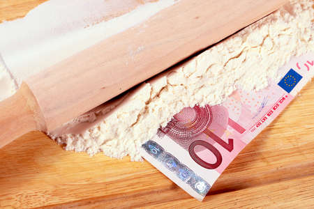 euro paper bills and wheat flour for bread on a wooden boardの写真素材