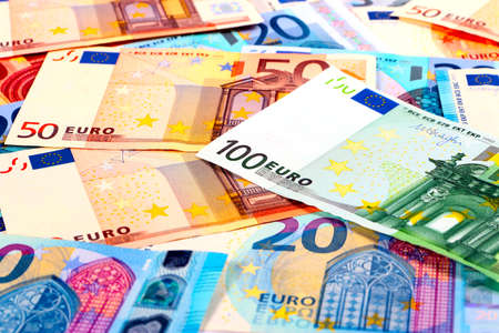 a small pile of paper euro banknotes as part of the European financial and trading system