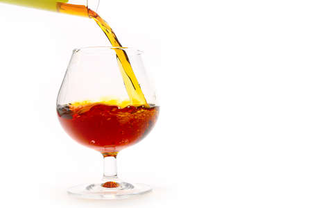 strong alcohol drink is poured from a bottle into a glass as a preparation for the holidayの写真素材